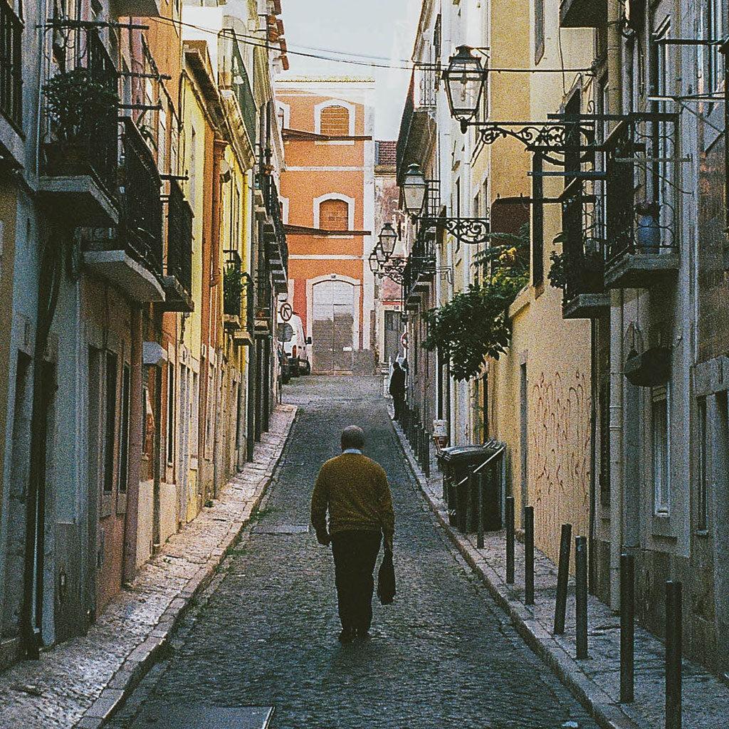 Alter Mann läuft durch eine Gasse in Lissabon