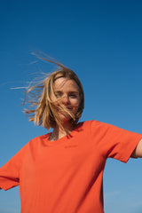 Frau trägt SALZWASSER T-Shirt in Orange in der Natur _women