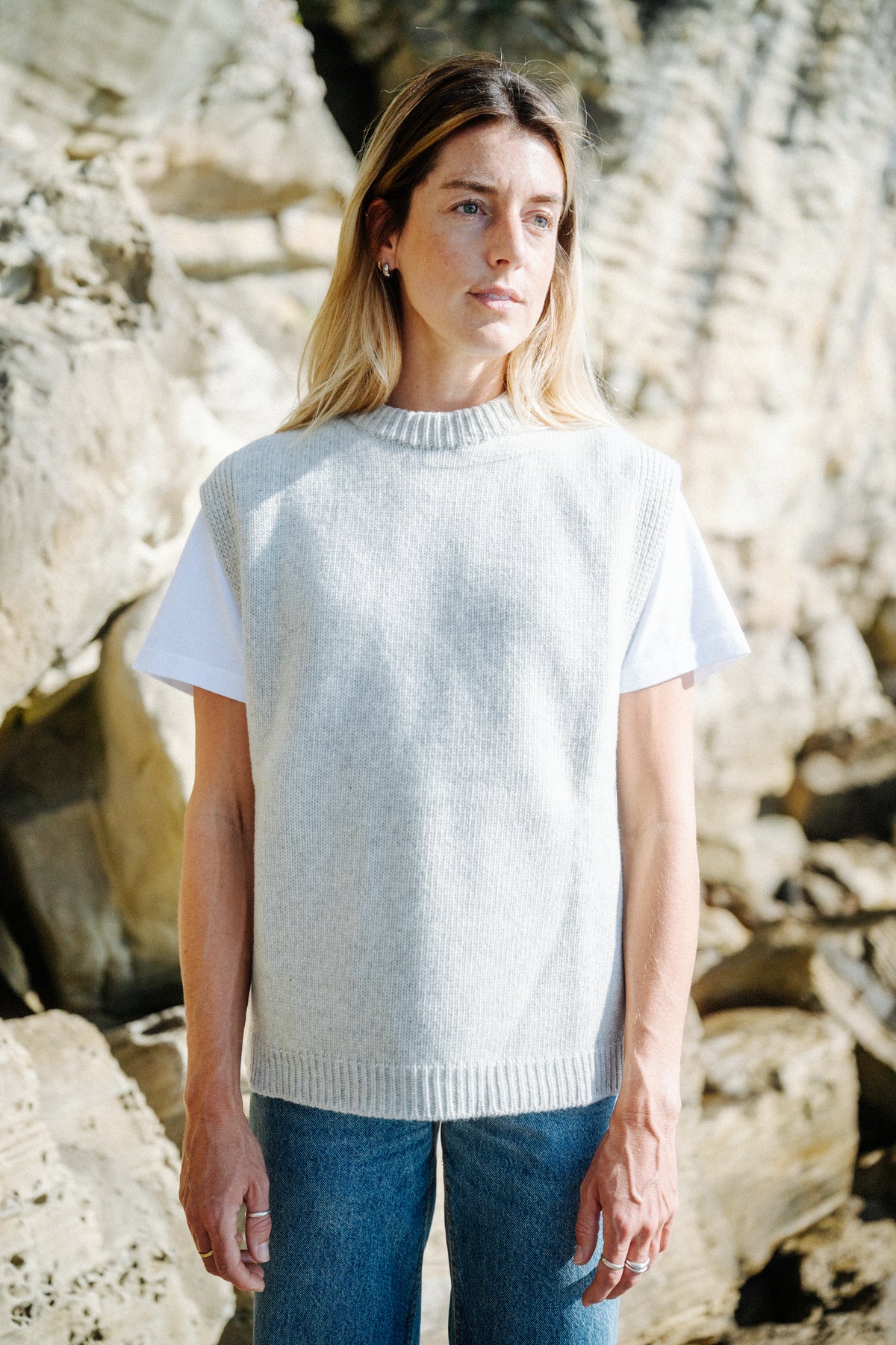 Frau im Unisex Woll Pullunder Hellgrau mit weißem T-Shirt und Jeans
