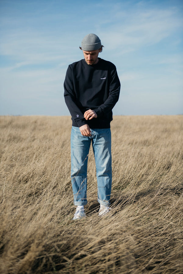 Mann trägt nachhaltigen Basic Sweater von SALZWASSER in der Natur _men