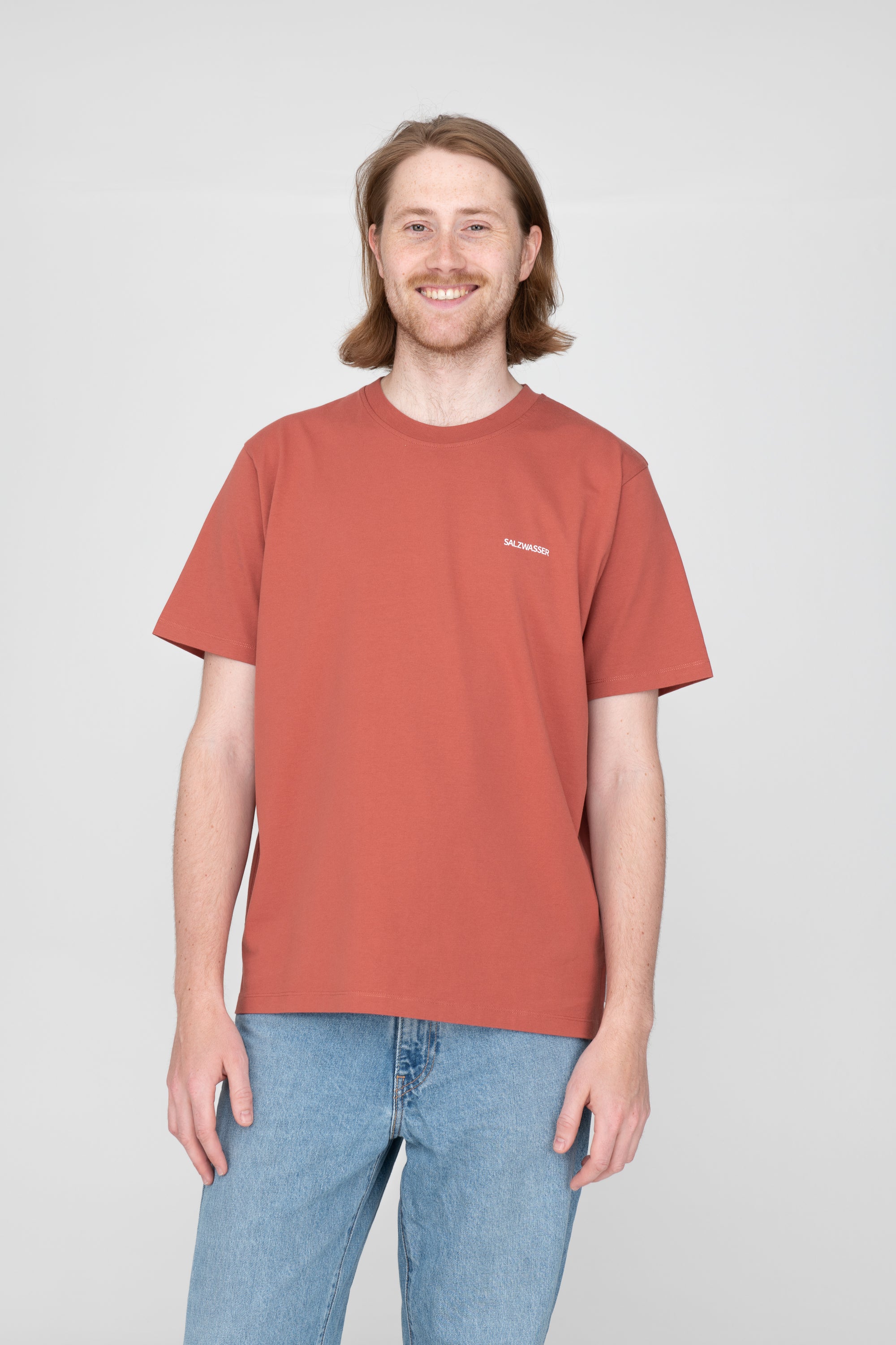 Mann trägt nachhaltiges T-Shirt von SALZWASSER in Rusty Red 