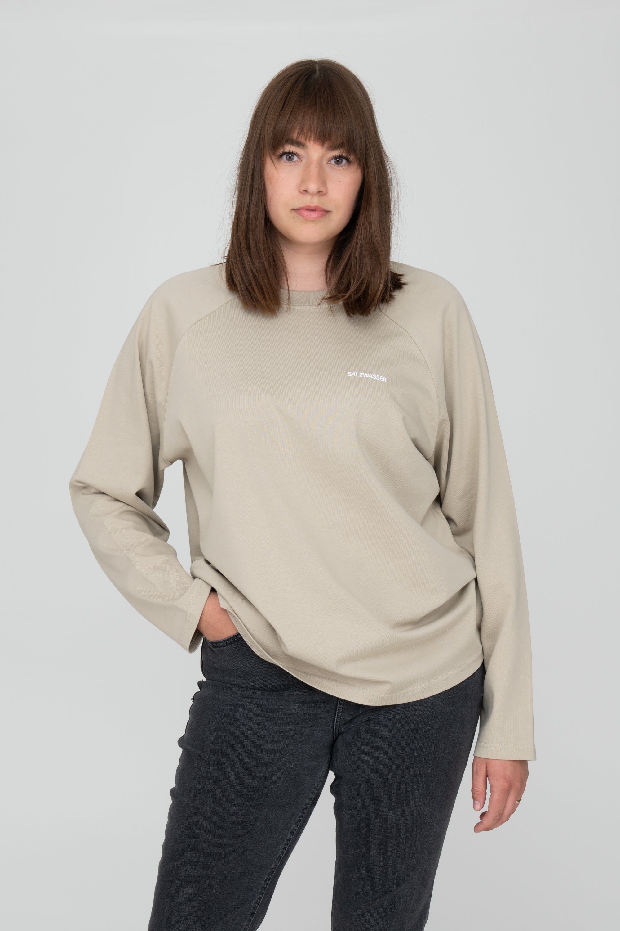 Frau trägt nachhaltiges Longsleeve von SALZWASSER in Sand mit Rückenprint