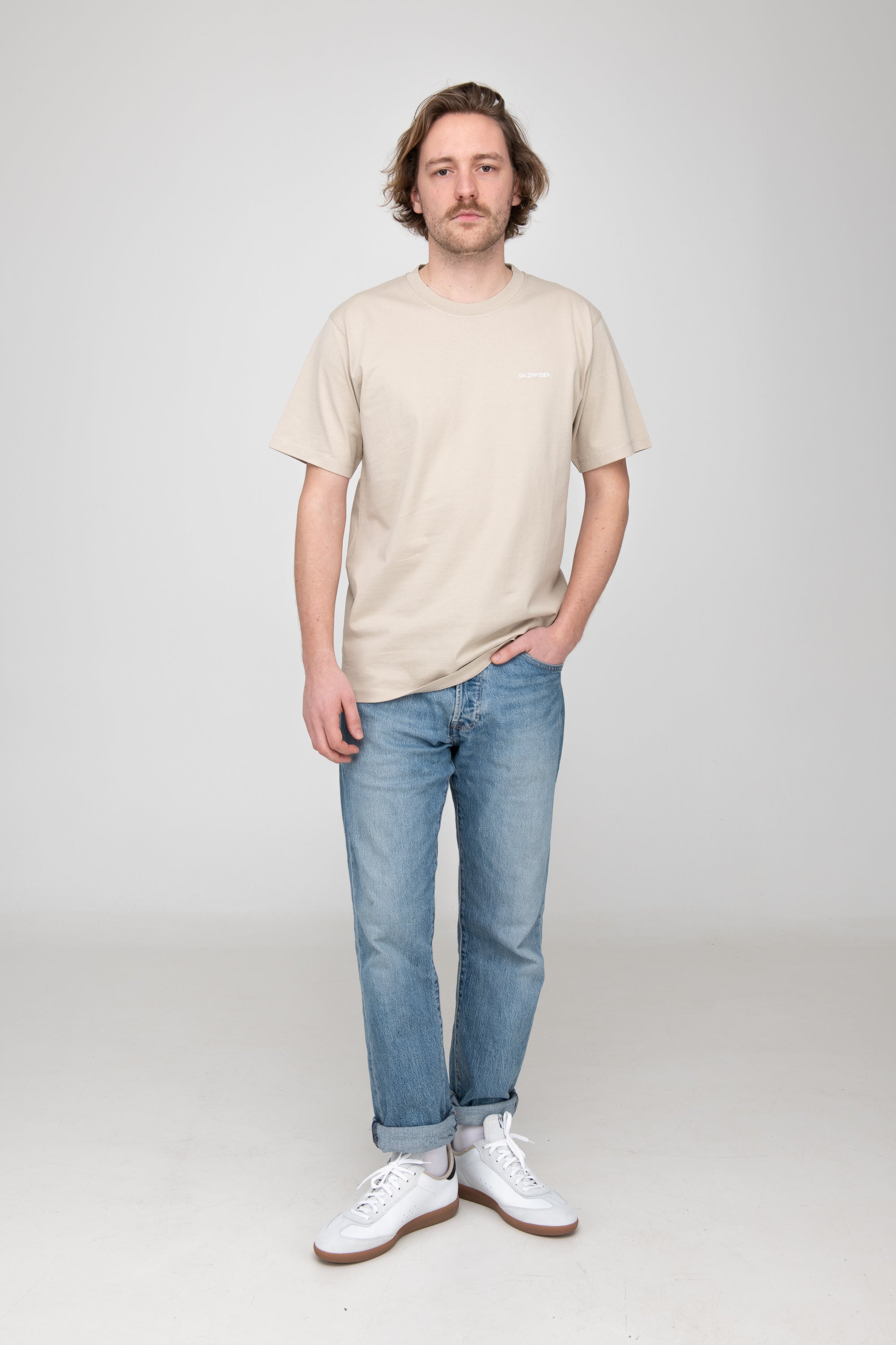 Mann trägt GOTS-zertifiziertes Sand-farbiges T-Shirt von SALZWASSER  Edit alt text
