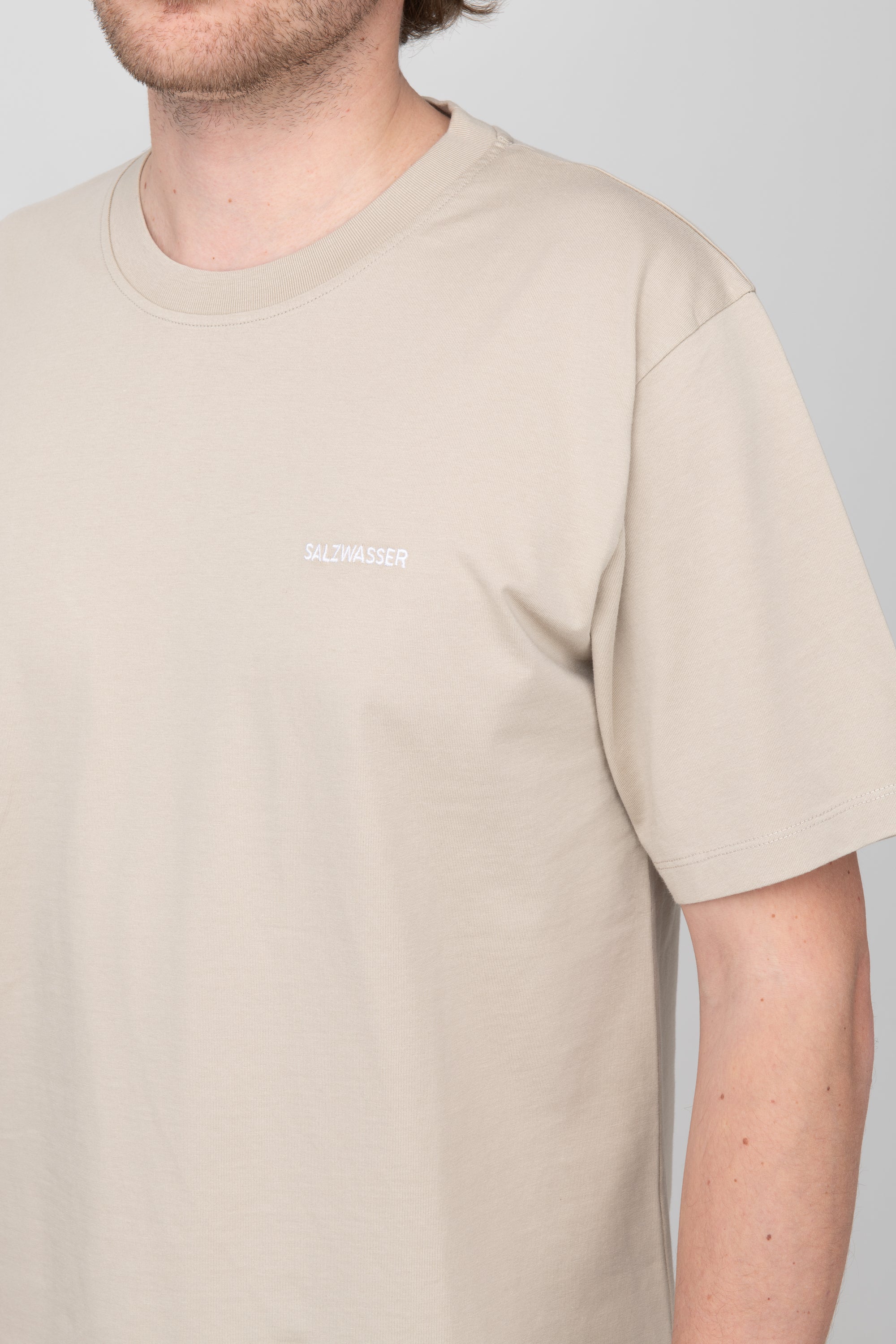 schlichtes T-Shirt in Sand mit weißer SALZWASSER-Stickerei