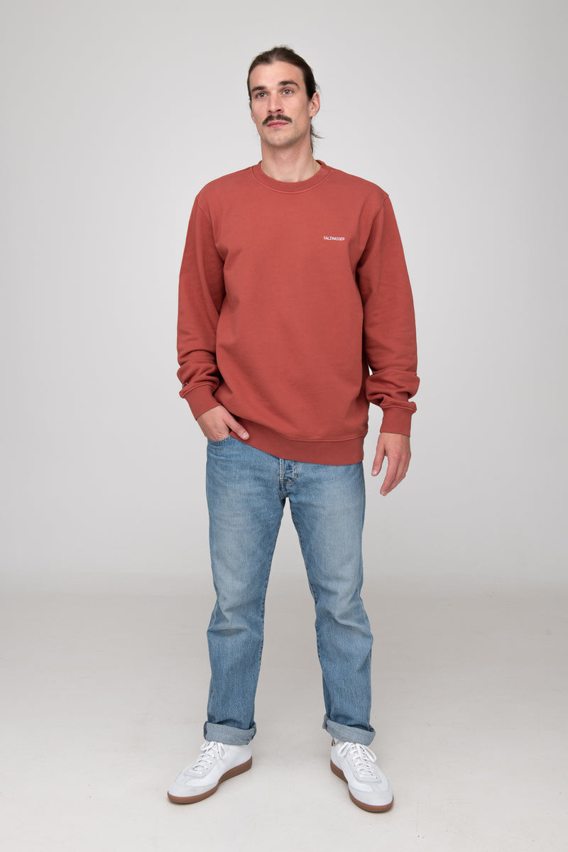 Mann trägt GOTS-zertifizierten Rostroten Sweater von SALZWASSER
