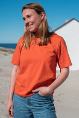 Frau trägt GOTS-zertifiziertes Orange-farbiges T-Shirt von SALZWASSER